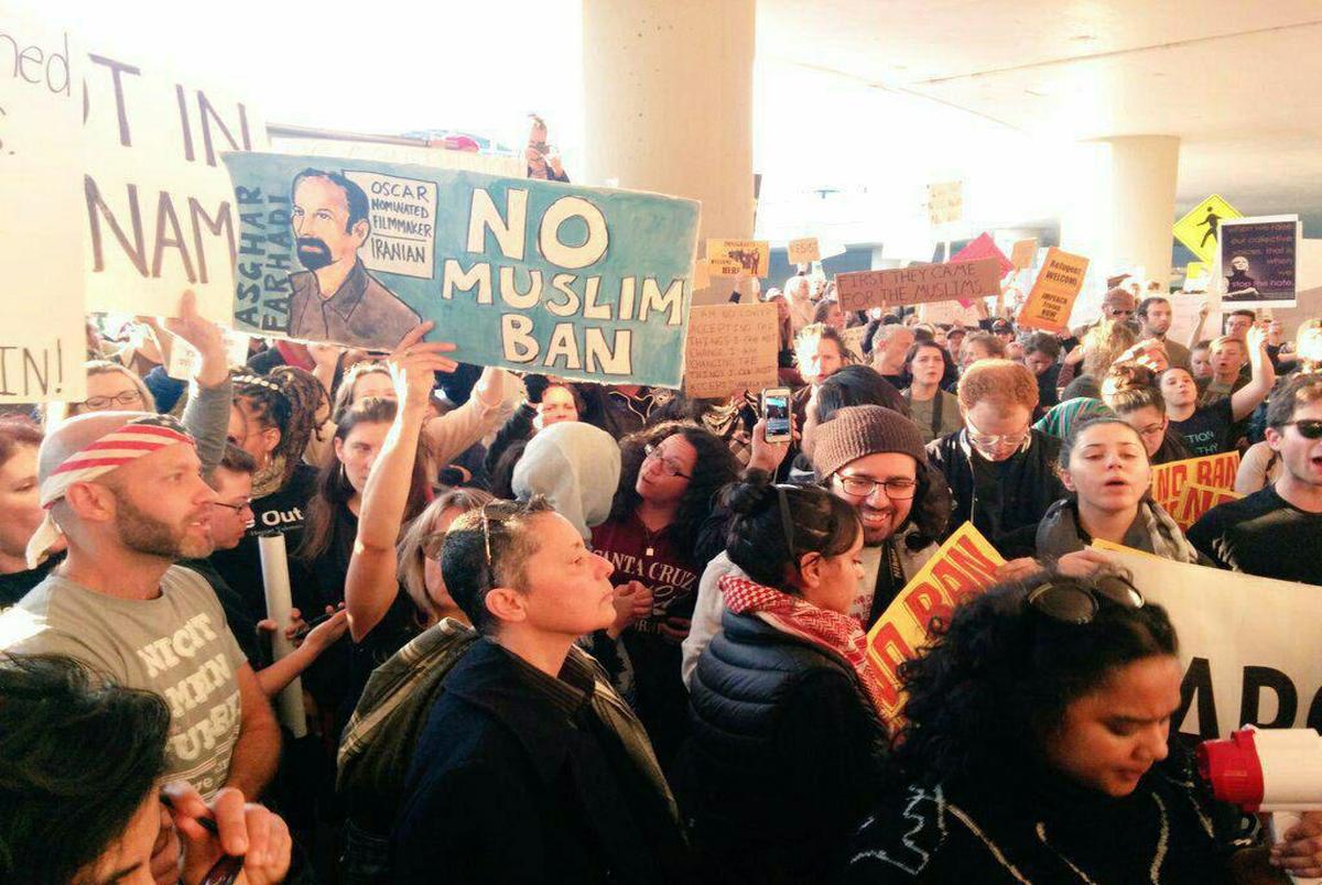 تصویر  اصغر فرهادی در دستان تظاهرات کنندگان نیویورک