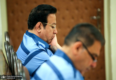 حسین هدایتی با دستبند و ماسک در راهرو دادگاه کیفری تهران
